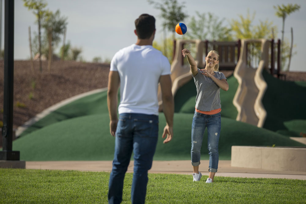 a couple playing catch at the park