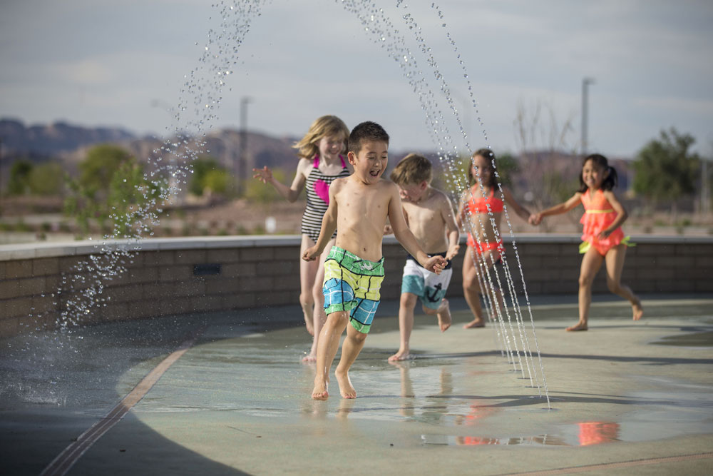 kids playing at water fountain